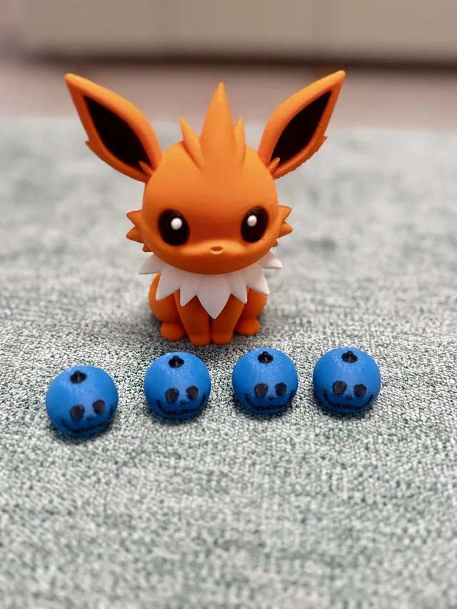 An orange fox-like character print with large ears and a white neck ruff, beside four small blue pieces